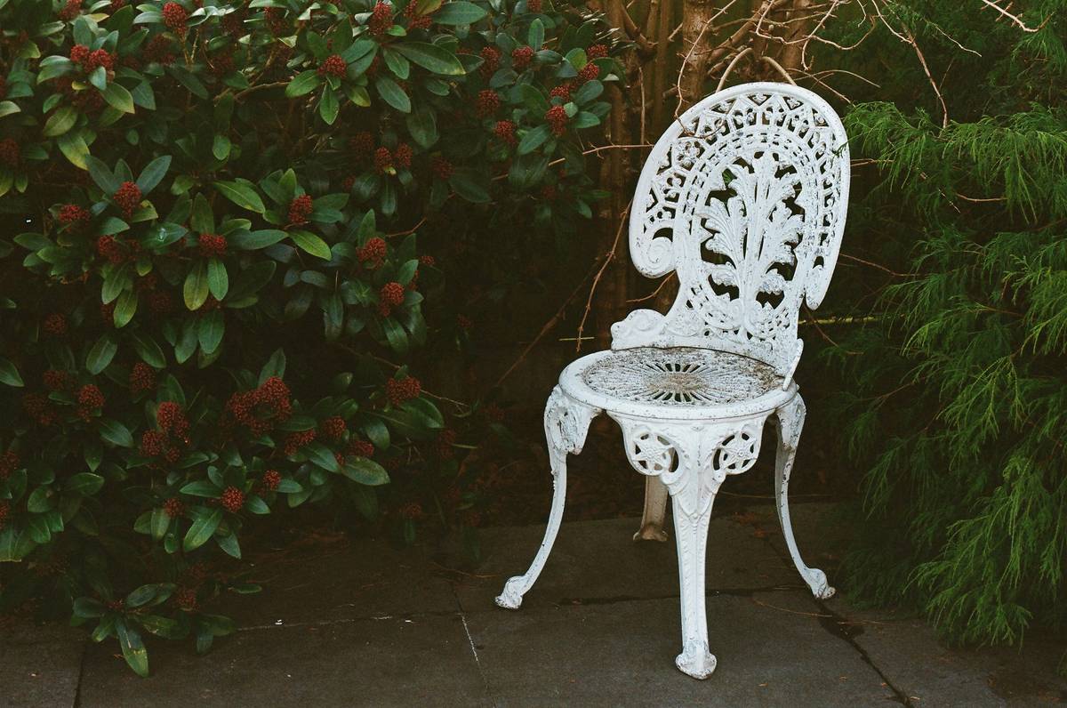 outdoor seating garden chair can you trust this wooden chair on a rainy patio? Shows water pooling around legs and faded finish.