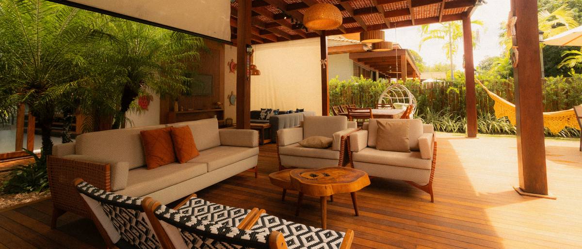 Stacked commercial outdoor garden furniture made of powder-coated aluminum and all-weather wicker on a sunny patio